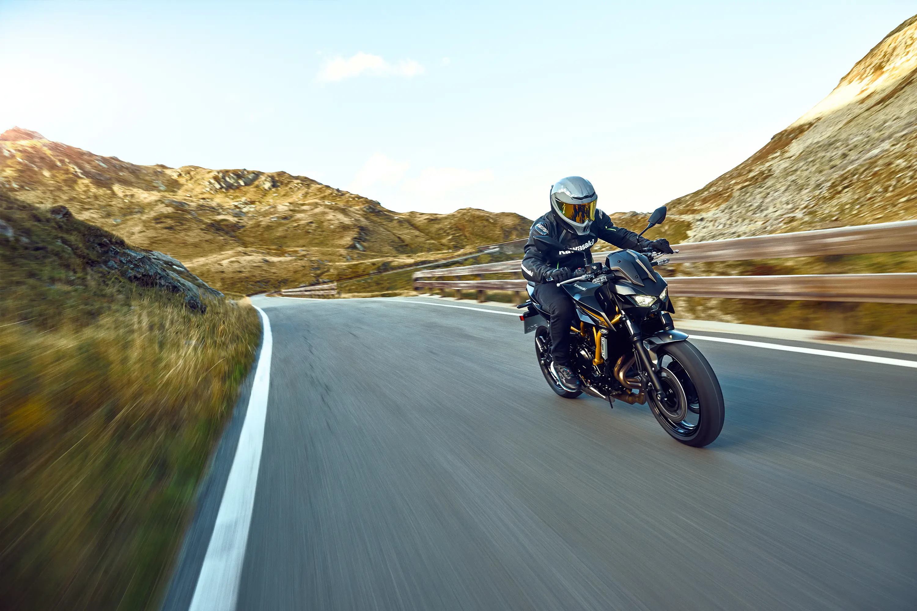 Three-quarter front angle of a person riding a motorcycle on a highway.