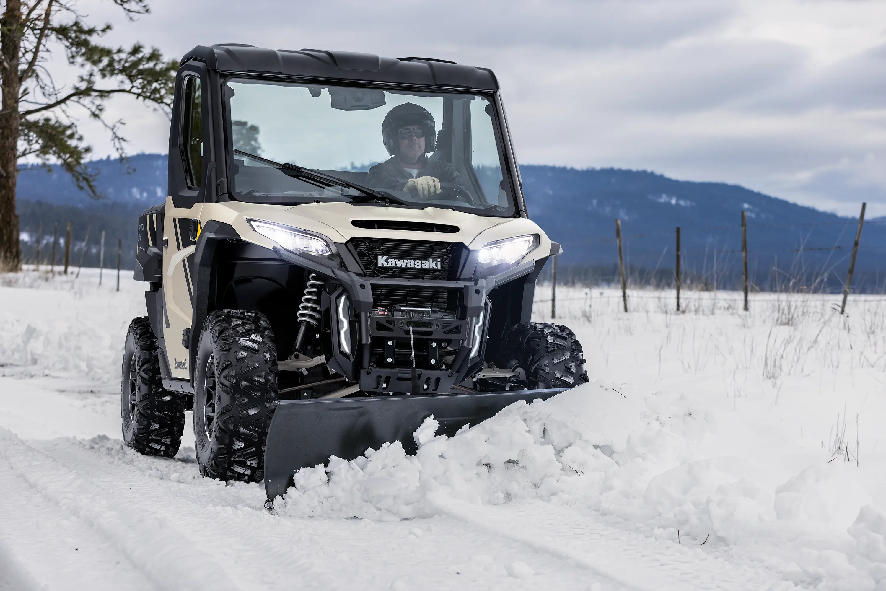 Front angle of a person plowing snow with their side x side.
