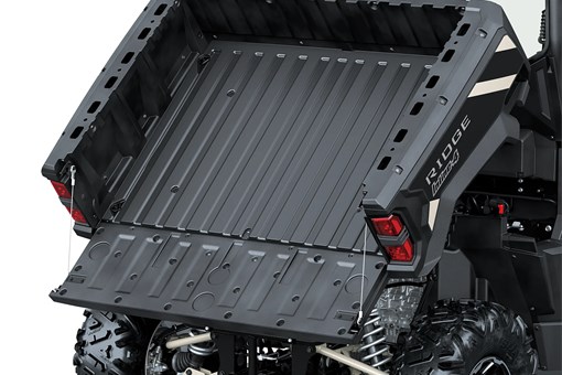 A full view of the tilting cargo bed of a side x side staged in a white studio background. opens in a new window