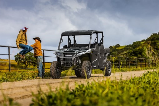 Three-quarter front angle of a side x side parked on a farm road. opens in a new window
