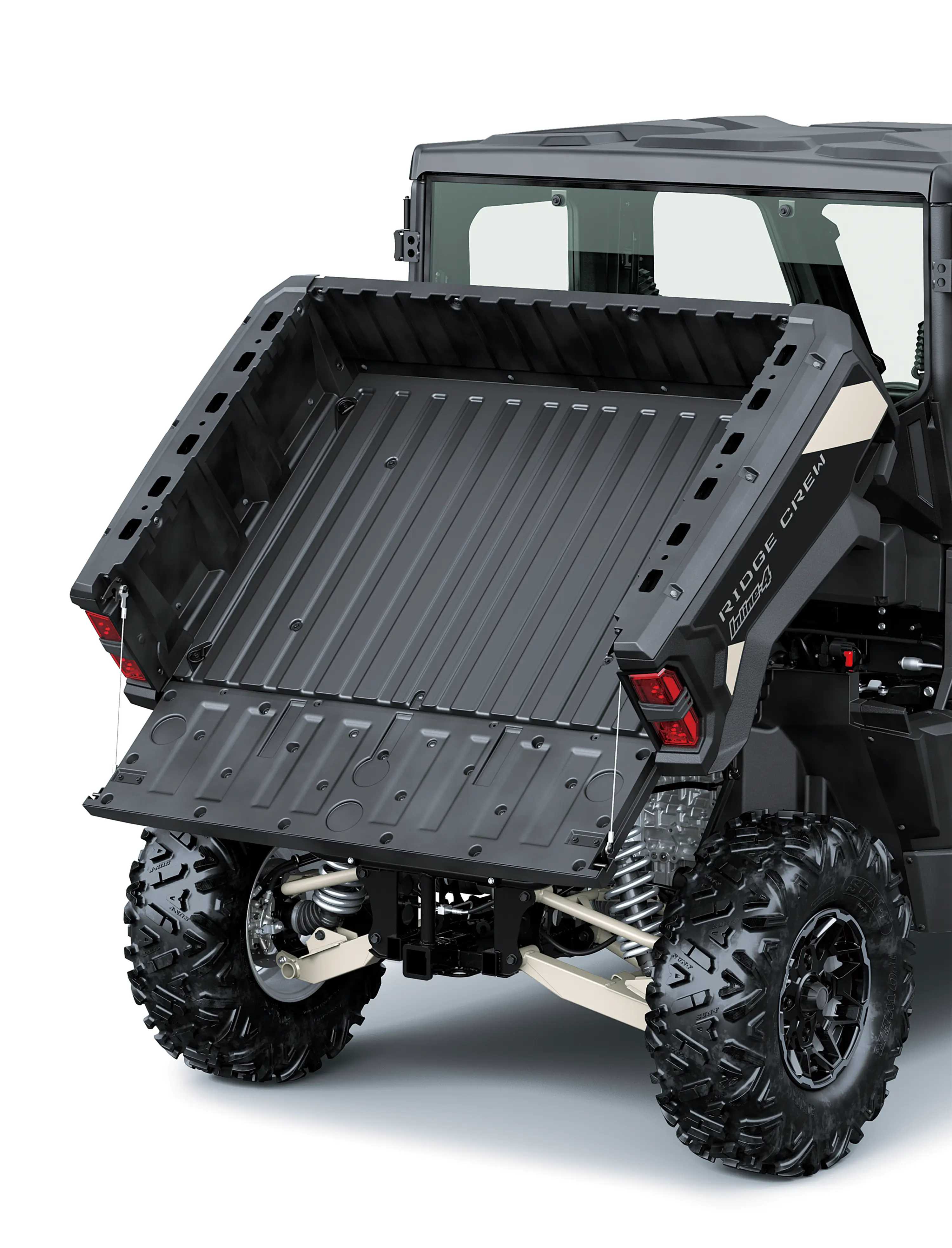 A full view of the tilting cargo bed of a side x side staged in a white studio background.