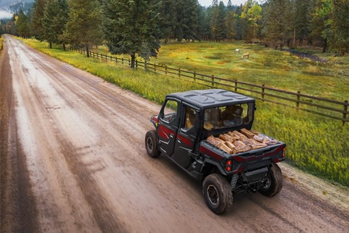 Rear aerial view of person driving a side x side on a dirt road. opens in a new window
