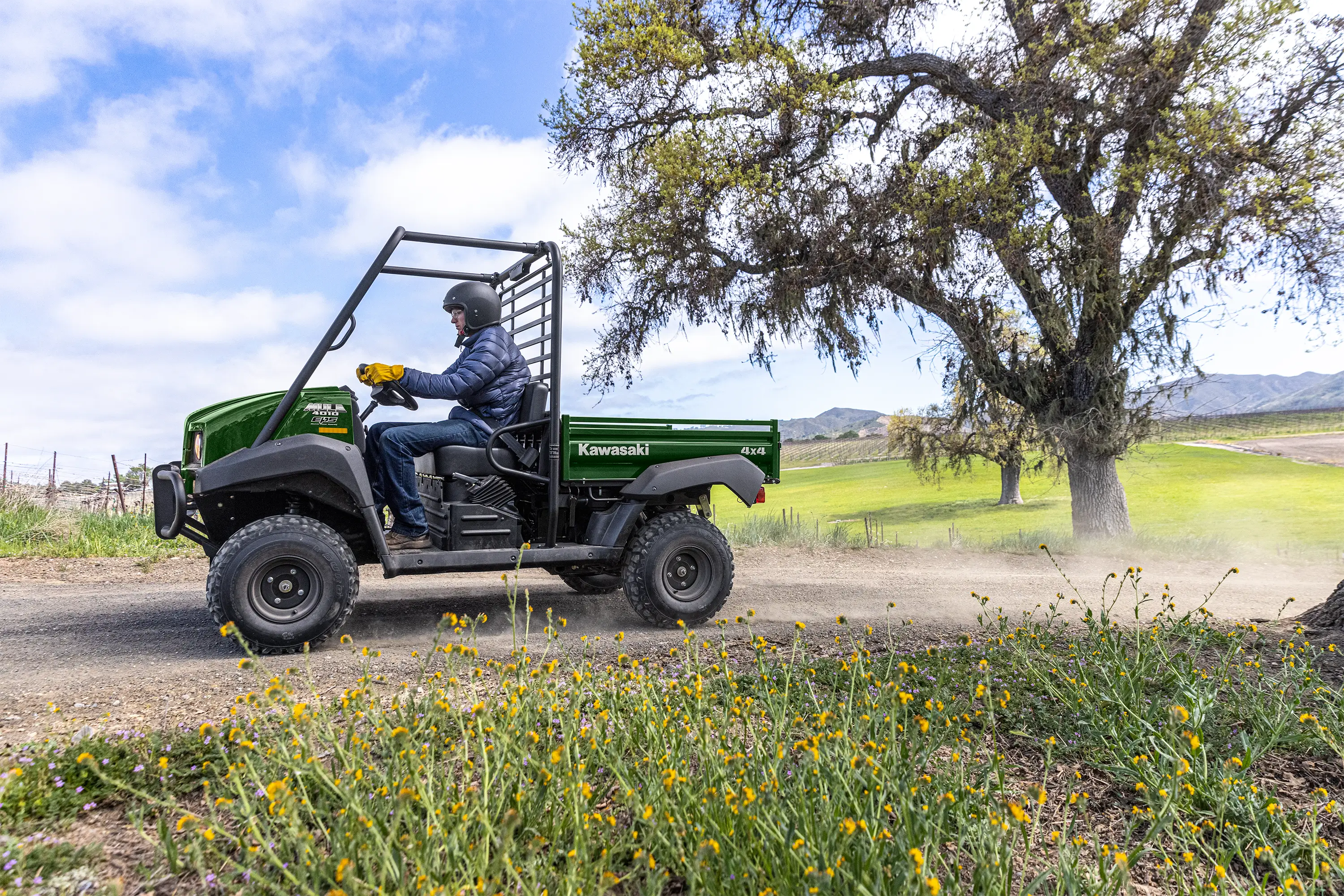 Side angle of a person driving a side x side at a ranch.