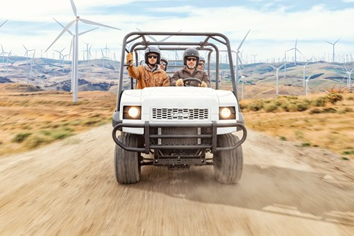 Front angle of four people riding a side x side on a jobsite. opens in a new window