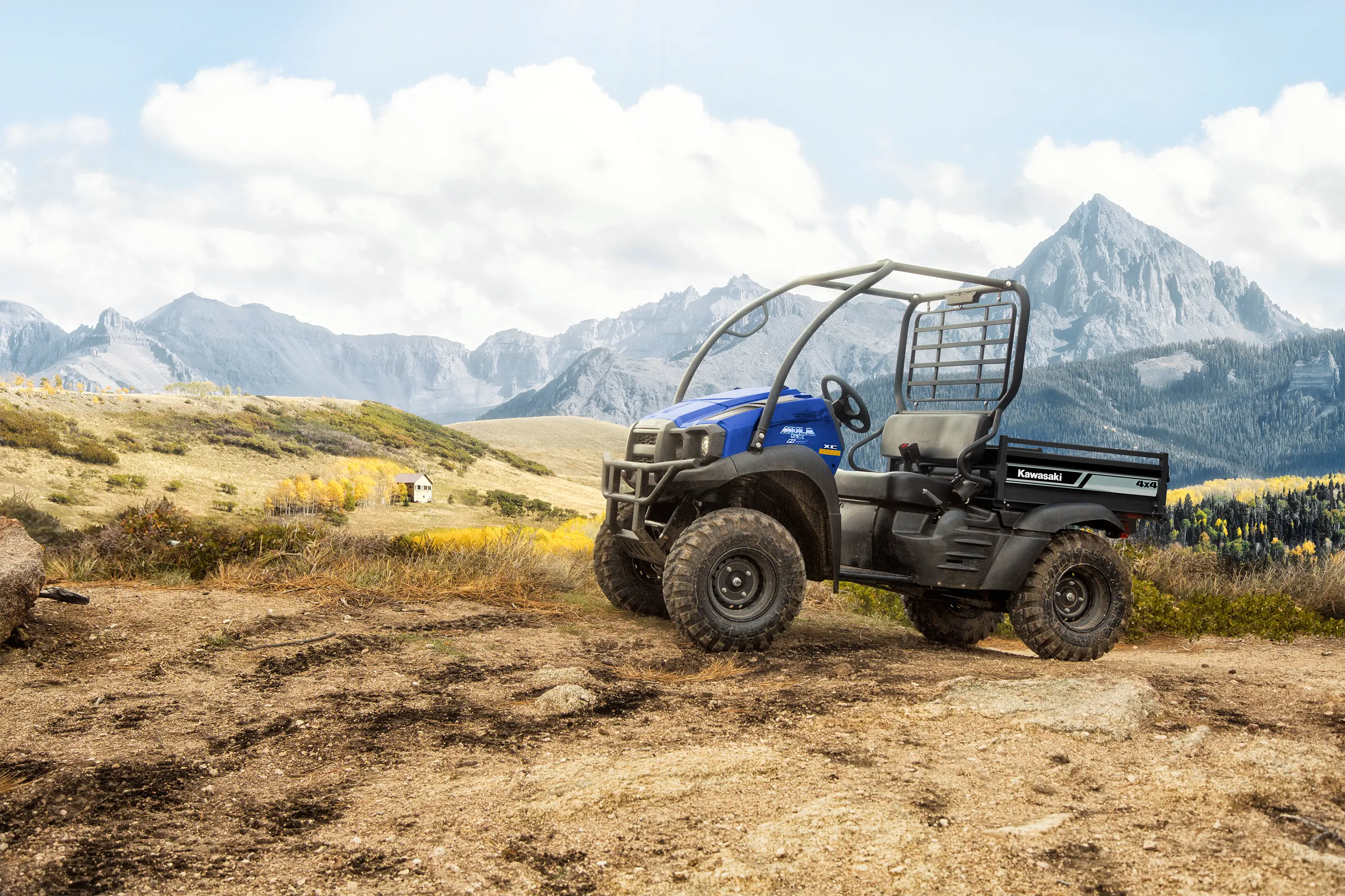 A blue side x side parked in front of a scenic mountain view.