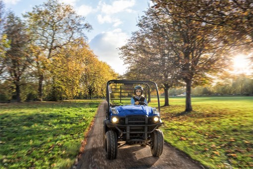 Front view of a person driving a blue side x side on a scenic country road. opens in a new window