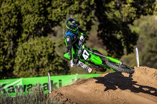 Front angle of a person riding a motorcycle over a jump on a dirt track. opens in a new window