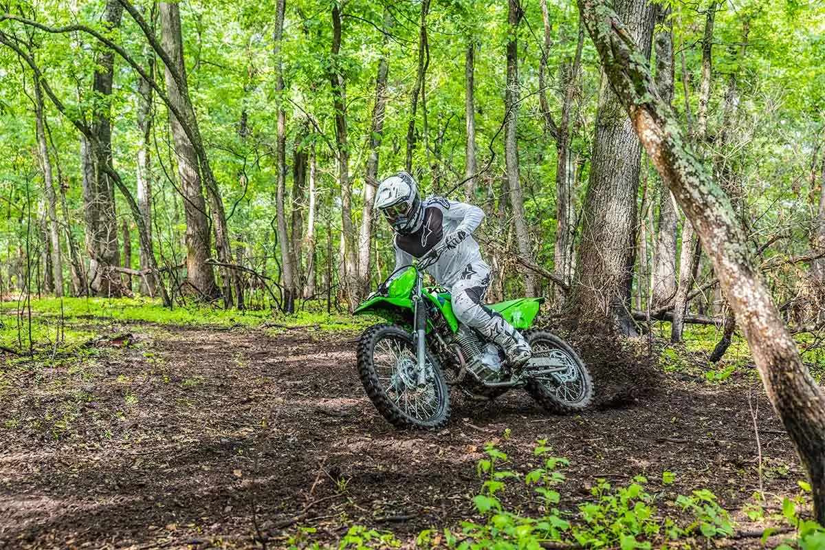 Three-quarter front angle of a person riding a motorcycle off-road.