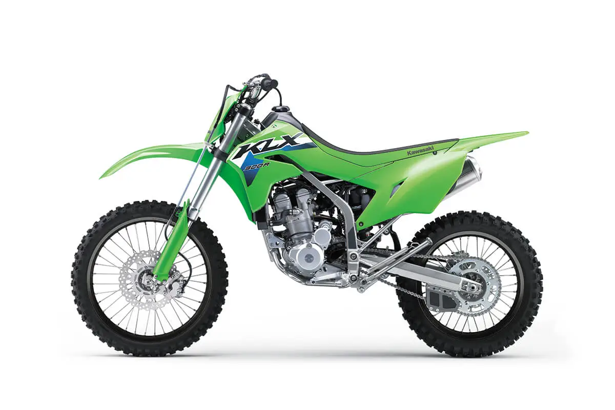 Left side view of a green dirt bike staged in a white studio background.
