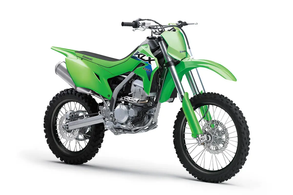 Front three-quarter view of a green dirt bike in a white studio background.