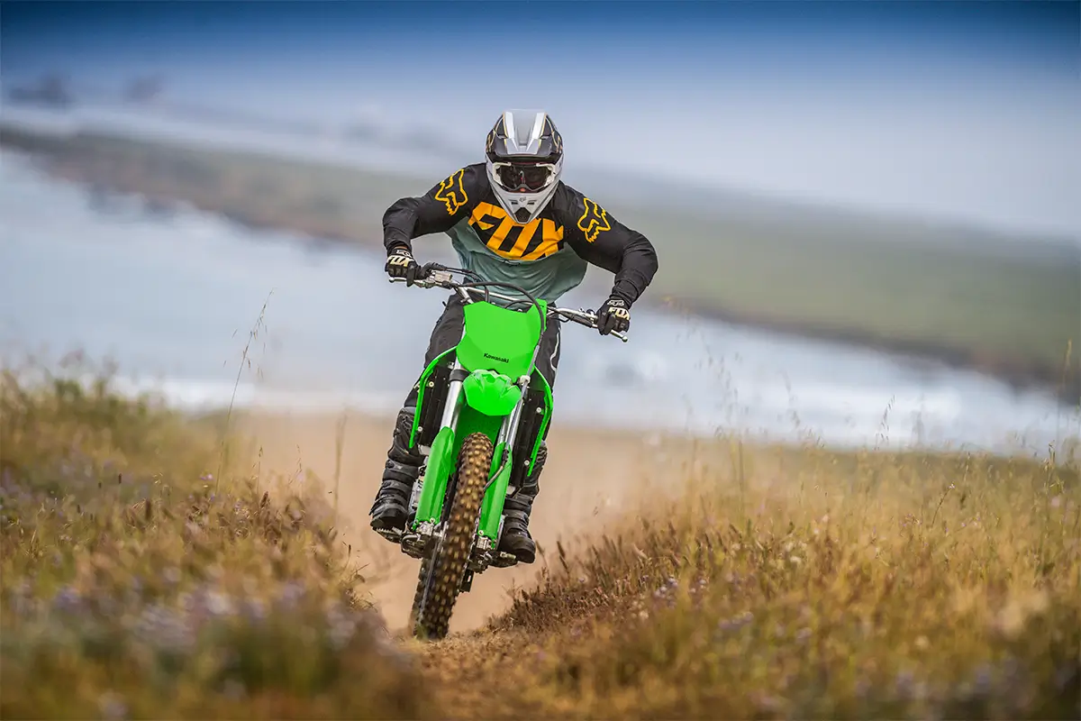 Oncoming view of a person riding an off-road dirt bike on a fast trail.
