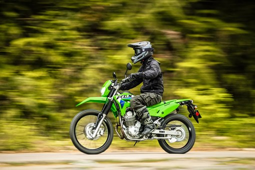 Profile angle of a person riding a motorcycle off-road. opens in a new window