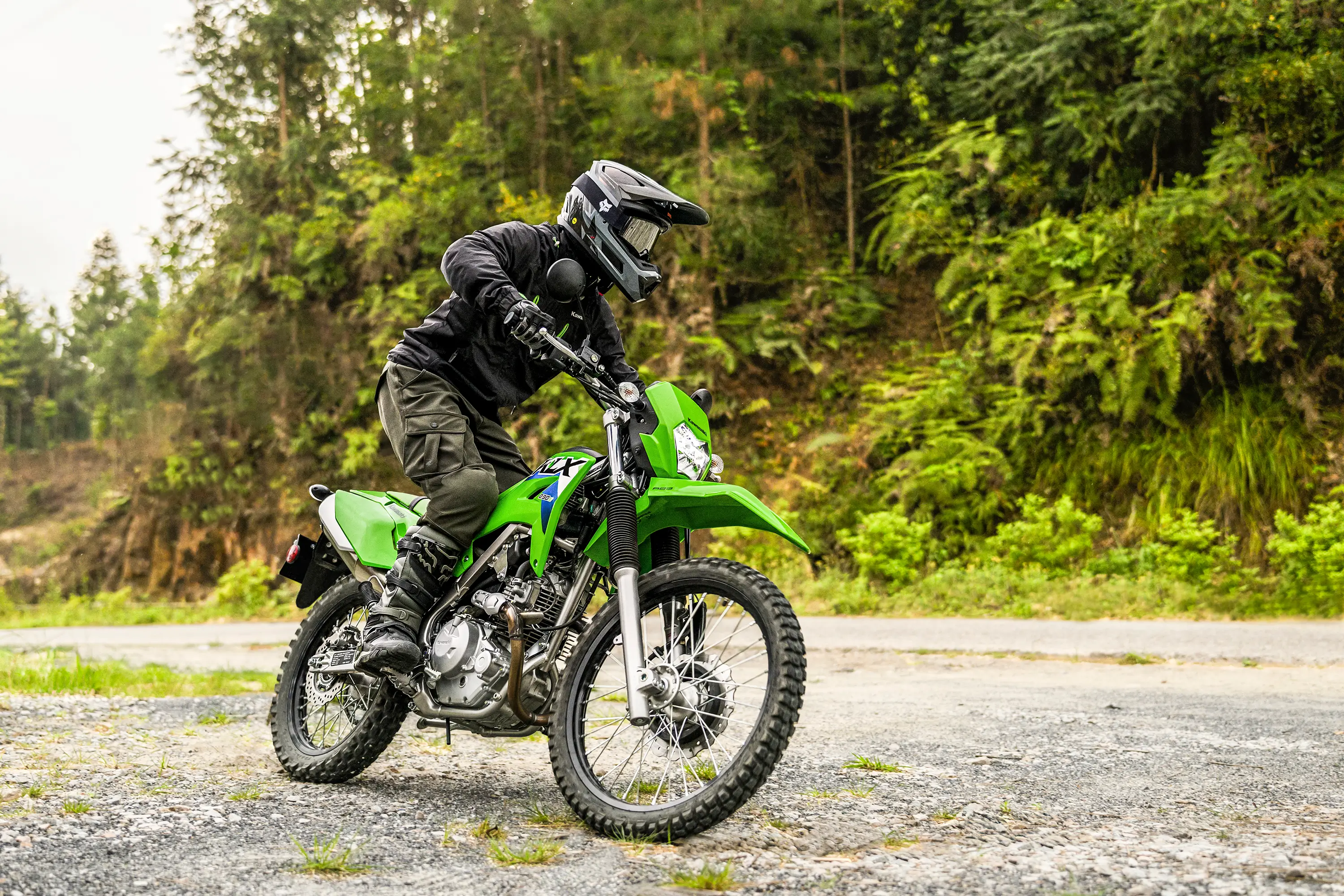 Three-quarter front angle of a person riding a motorcycle off-road.