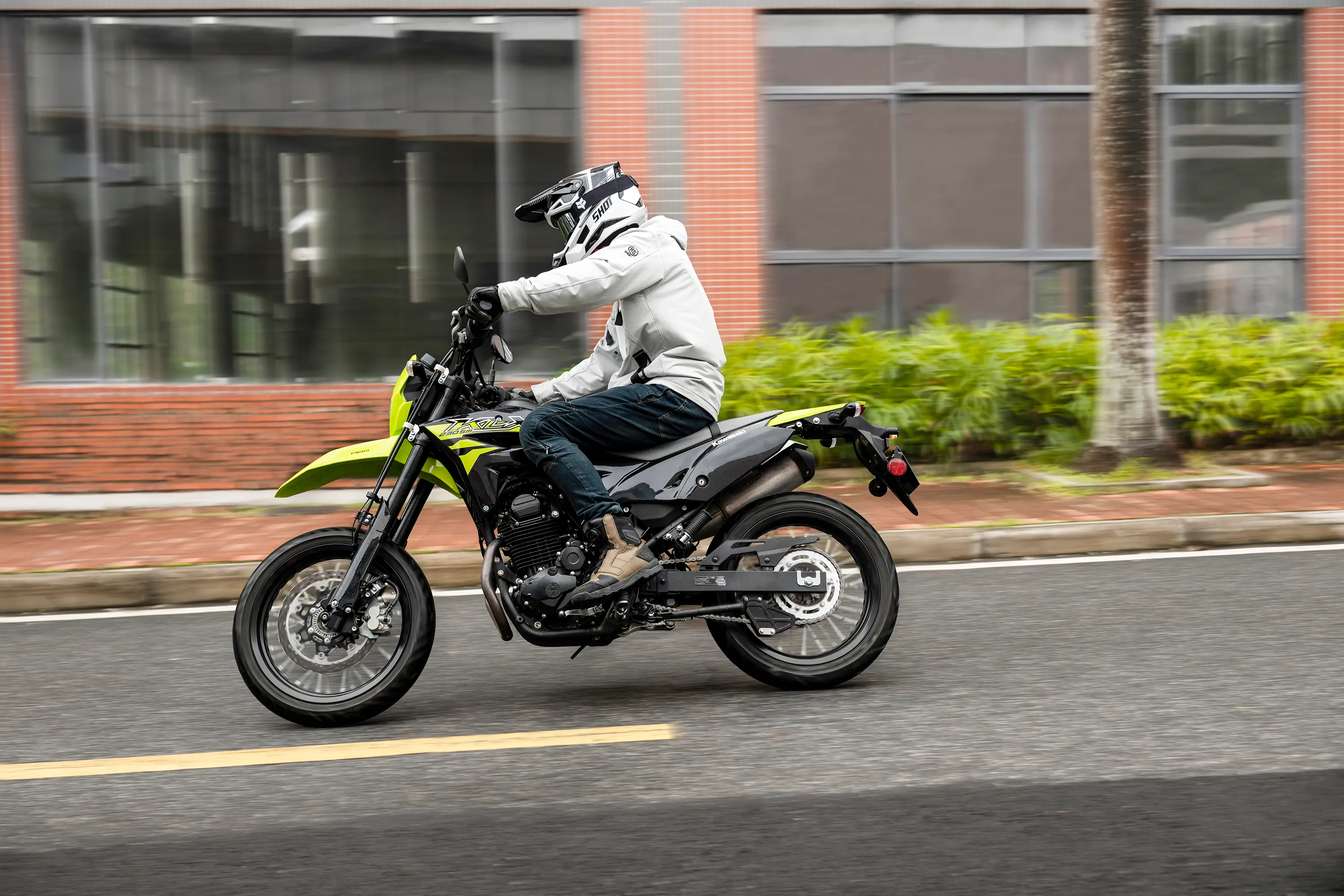Profile angle of a person riding a motorcycle on a city street.