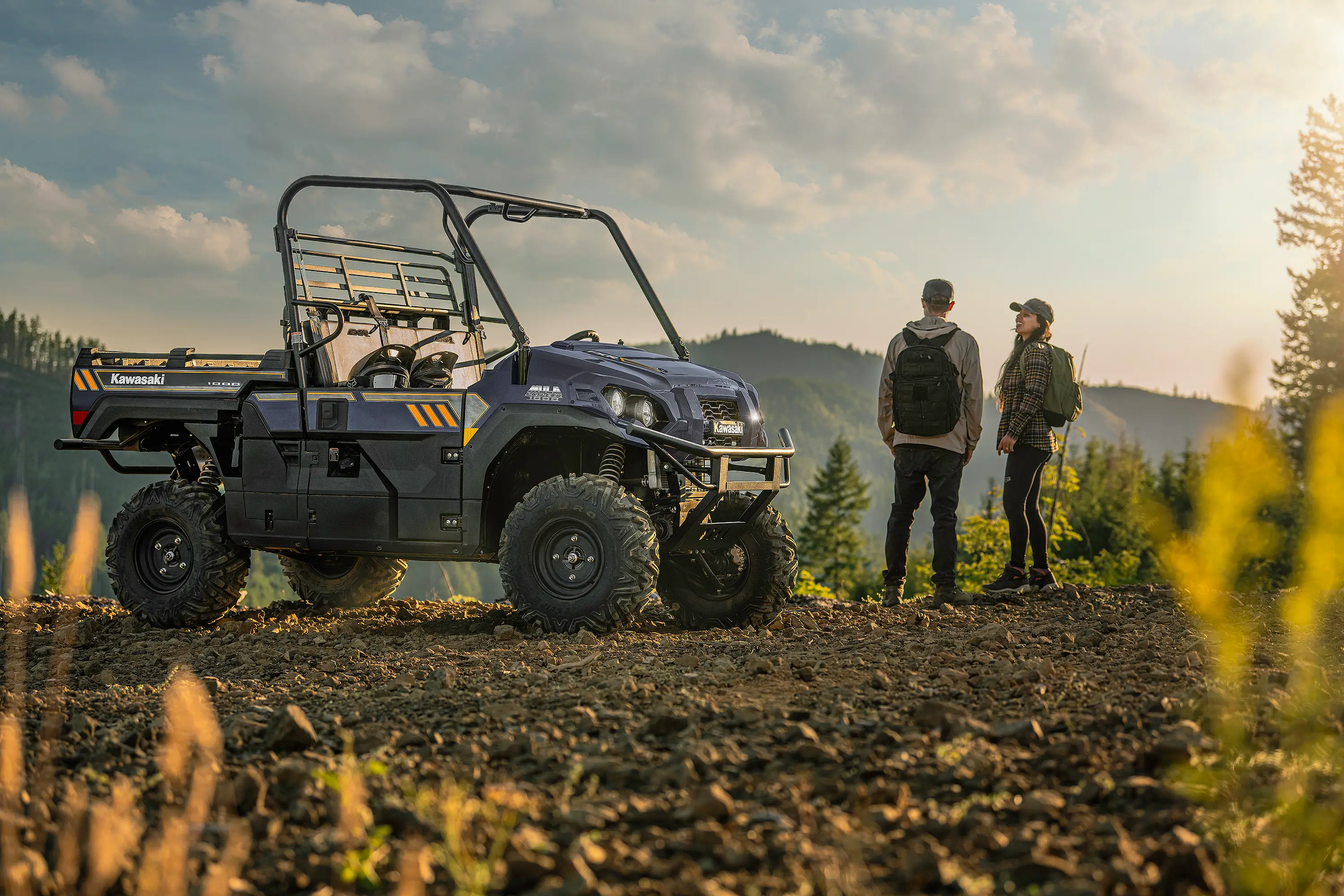 Side x side parked in front of a scenic mountain view with two people.