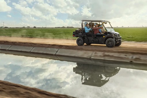Side angle of six people riding in a side x side at a jobsite. opens in a new window