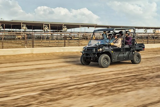 Three-quarter front angle of six people riding in a side x side at a jobsite. opens in a new window