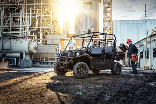 Three-quarter front angle of a person loading the bed of a parked side x side at a jobsite. opens in a new window