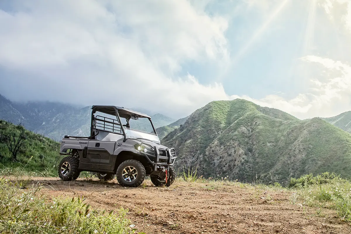 Three-quarter view of a side x side parked on a scenic hilltop.