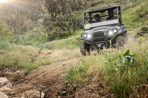 Front view of a side x side coming down a rugged dirt road. opens in a new window