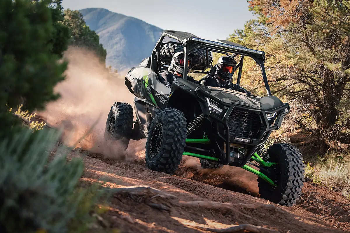 Front angle of two people driving a side x side off-road.