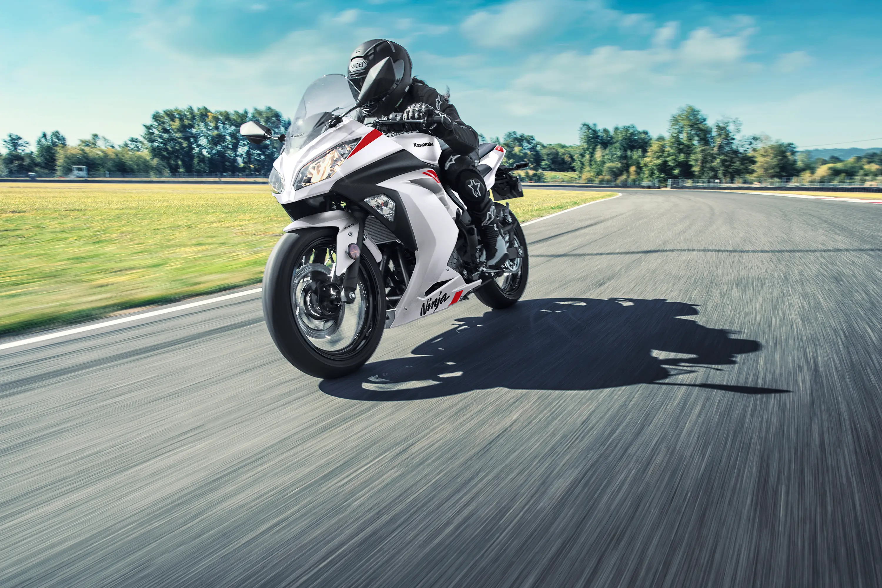 Three-quarter front angle of a person riding a motorcycle on a track.