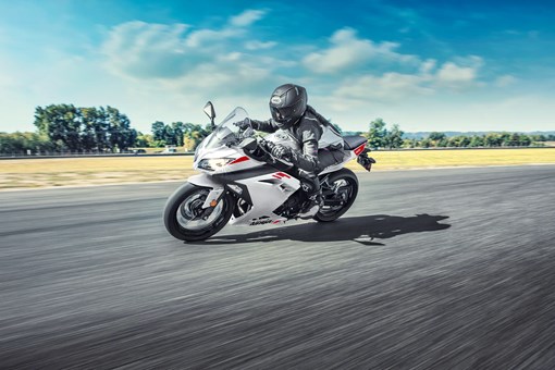 Side angle of a person riding a motorcycle on a track. opens in a new window