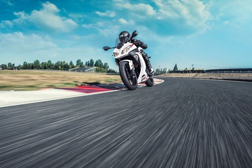 Front angle of a person riding a motorcycle on a track. opens in a new window