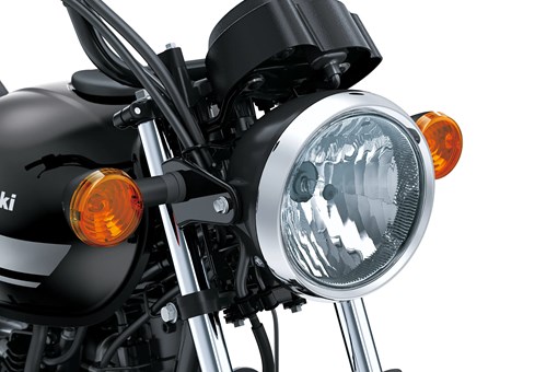 Close-up of the headlamp of a motorcycle staged in a white studio background. opens in a new window