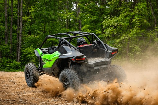 Three-quarter rear angle of a person driving a side x side off-road. opens in a new window