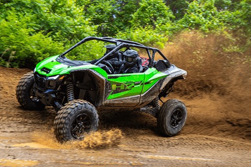 Side angle of a person driving a side x side off-road. opens in a new window