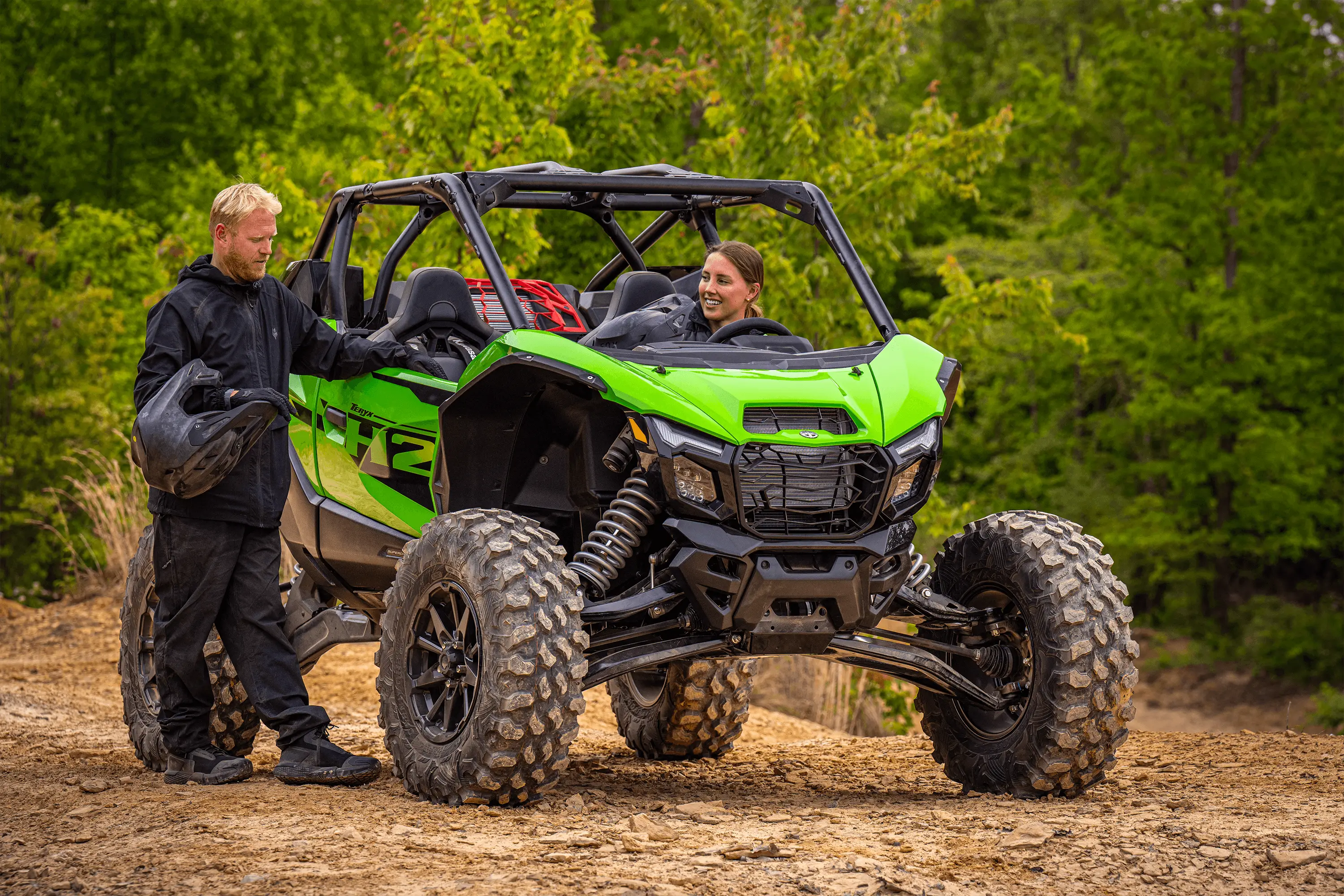 Three-quarter front angle of two people with a side x side parked.