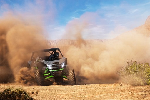 Three-quarter front angle of a person sliding a side x side off-road in the distance. opens in a new window